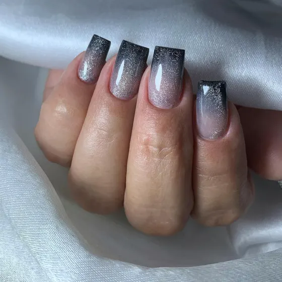 Uñas degradadas en negro con brillo plateado
